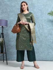 Woman wearing a green traditional outfit with a patterned scarf against a blue background